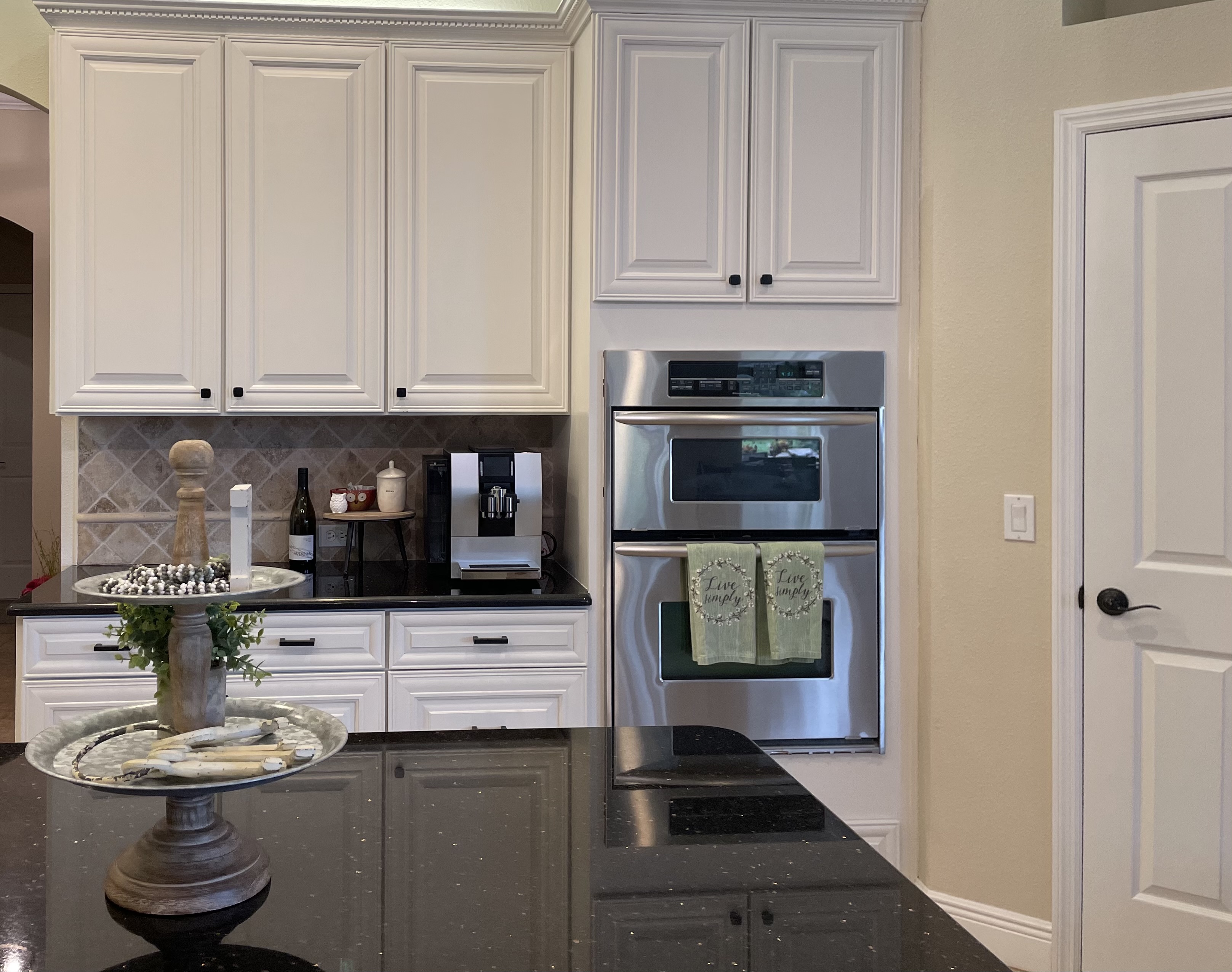 Kitchen with white cabinetry, warm wood accents, and natural light — Lithia, FL