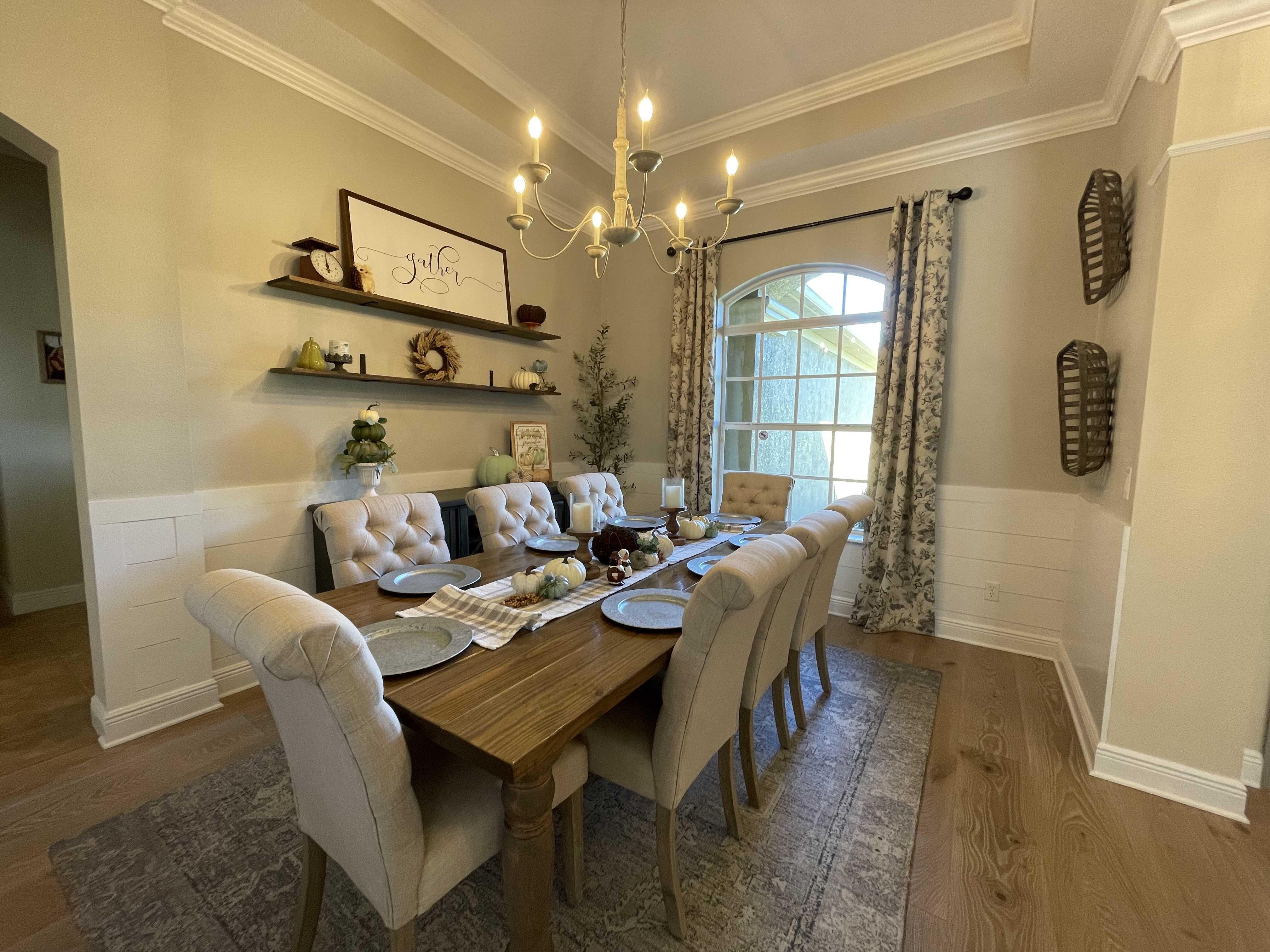 Dining room with farmhouse table, tufted linen chairs, floating shelves, and layered pendant lighting — Lithia, FL